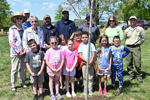  Students and representatives of organizations pose for a photo with the new red maple tree